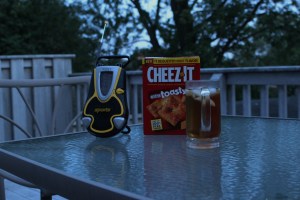 A scene at dusk: Cheez-Its, iced tea and portable radio on the deck table behind my house. Photograph by Sandra Cherrey Scheinin